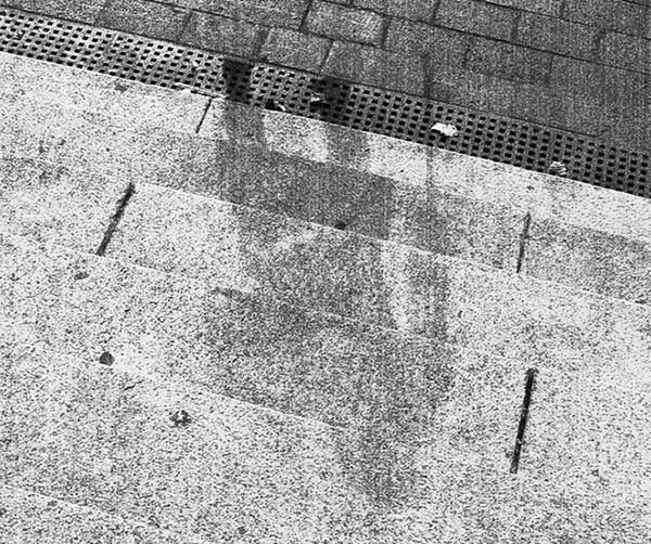 Bóng đen hình người và các đồ vật như xe đạp, được tìm thấy rải rác trên vỉa hè